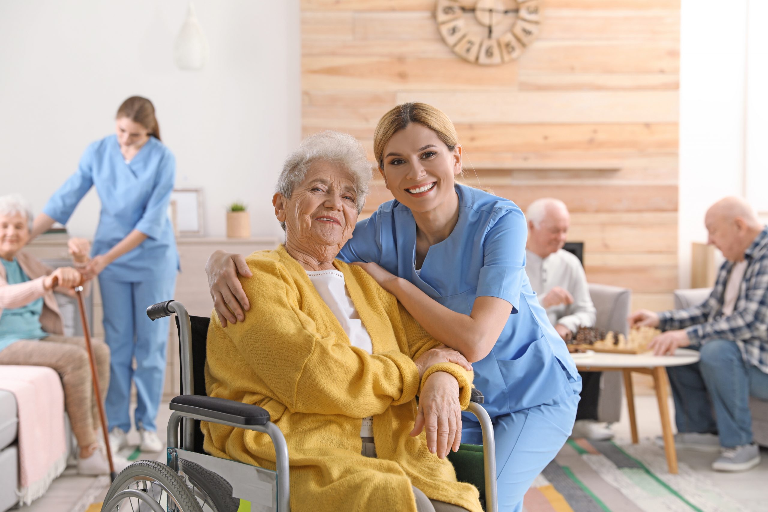 Infirmière et une mamie en fauteuil roulant dans une maison de retraite